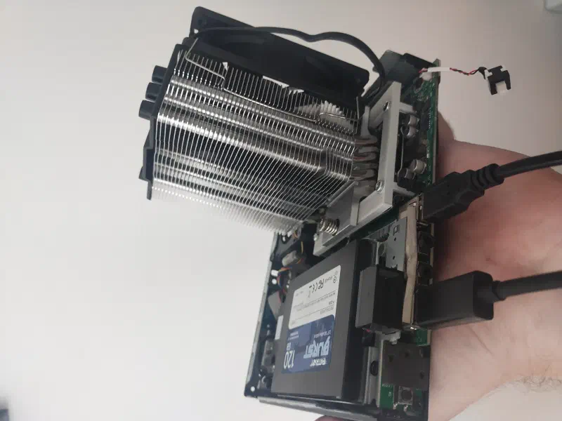 Miniaturowy komputer Lenovo Tiny trzymany w jednej dłoni